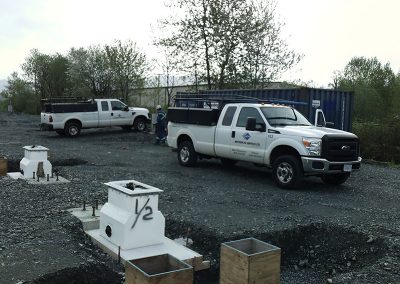 white trucks parked by a construction site being prepared