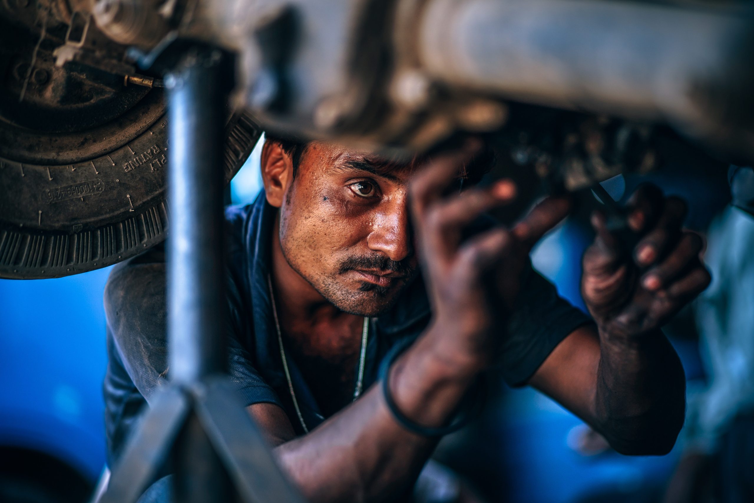 brown man working on a lifted vehicle