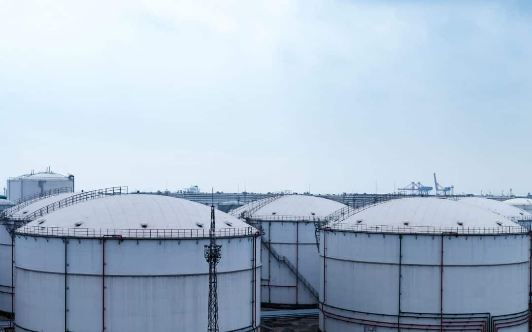 five giant storage tanks or facilities on a cold day