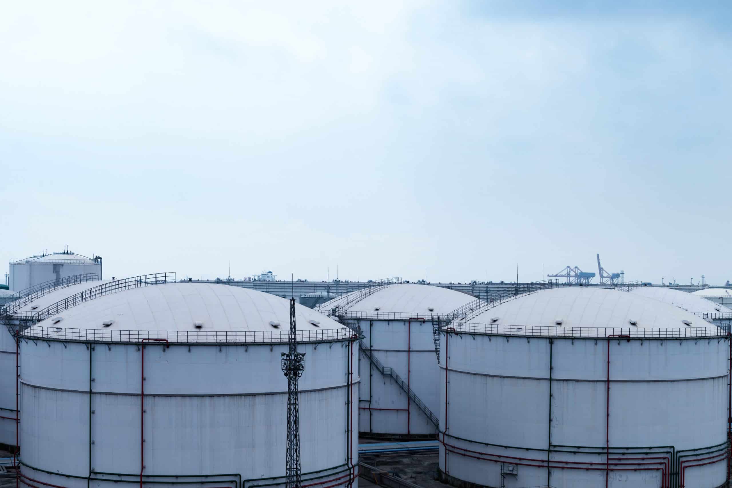 five giant storage tanks or facilities on a cold day