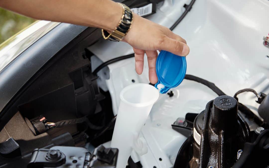 woman checking windshield washer fluid level