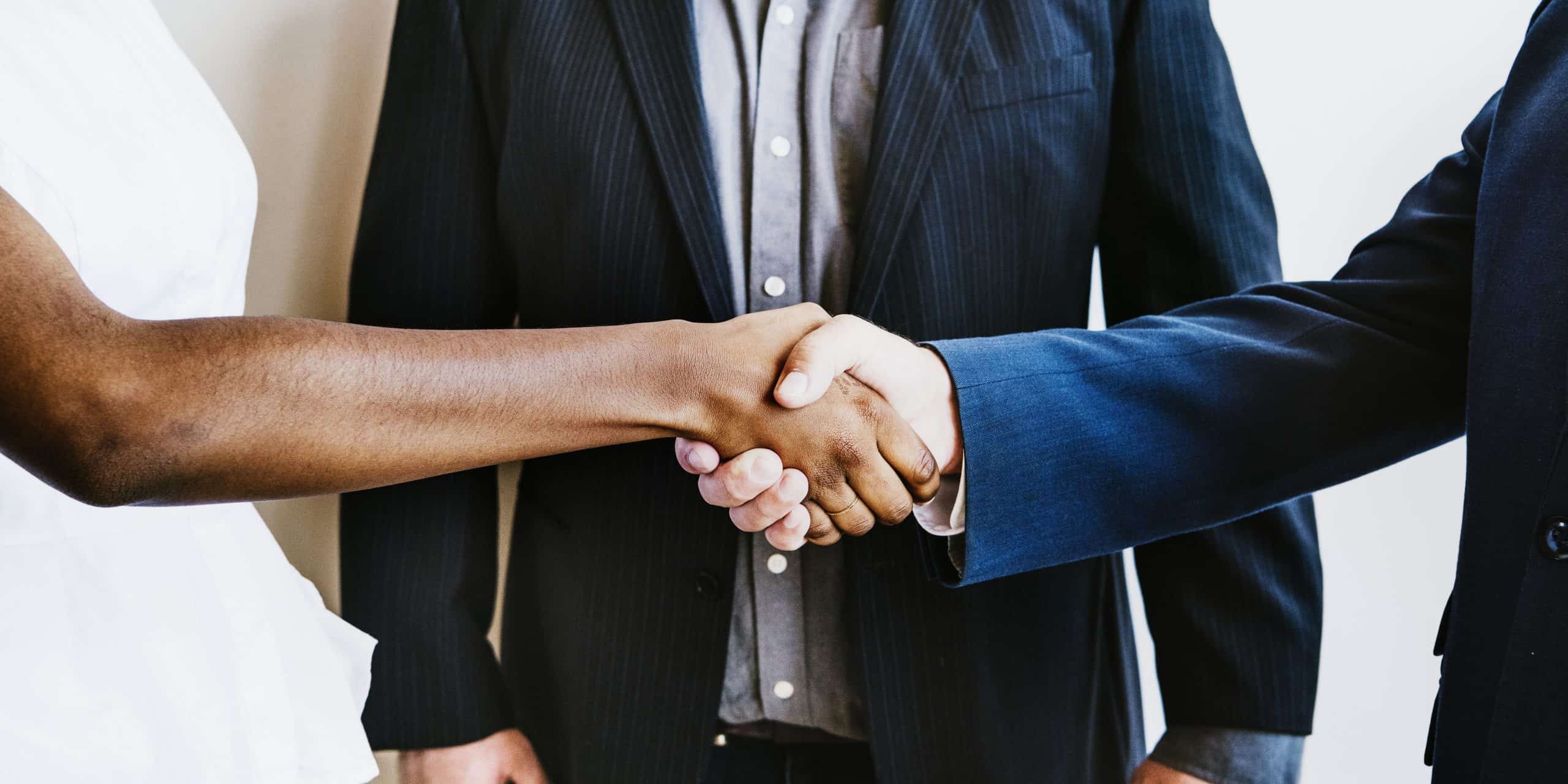 handshake between a black woman and white man